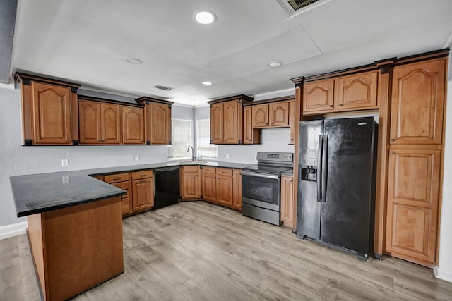 kitchen featuring sink, light hardwood / wood-style flooring, black appliances, and kitchen peninsula