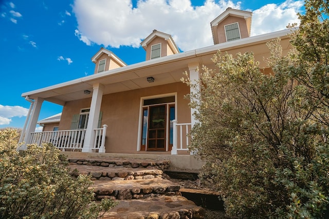 rear view of property featuring a porch