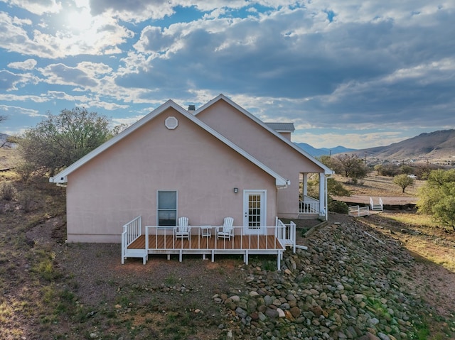 rear view of house with a deck with mountain view