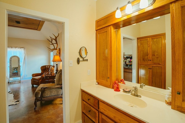 bathroom with concrete flooring, vanity, and lofted ceiling