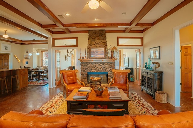 living room featuring beam ceiling, hardwood / wood-style flooring, a stone fireplace, and ceiling fan