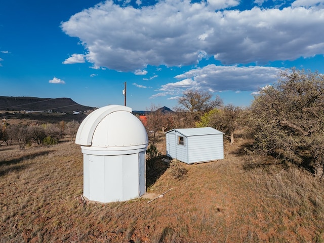 view of yard featuring a mountain view and a shed