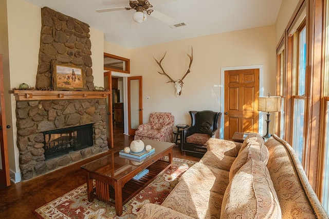 living room with a stone fireplace, ceiling fan, and a healthy amount of sunlight