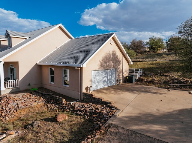 view of home's exterior featuring cooling unit and a garage