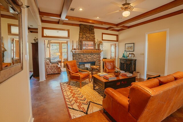 living room with beamed ceiling, ceiling fan, a fireplace, and concrete floors