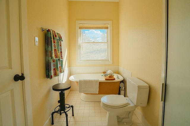 bathroom with a bathing tub, tile patterned flooring, and toilet