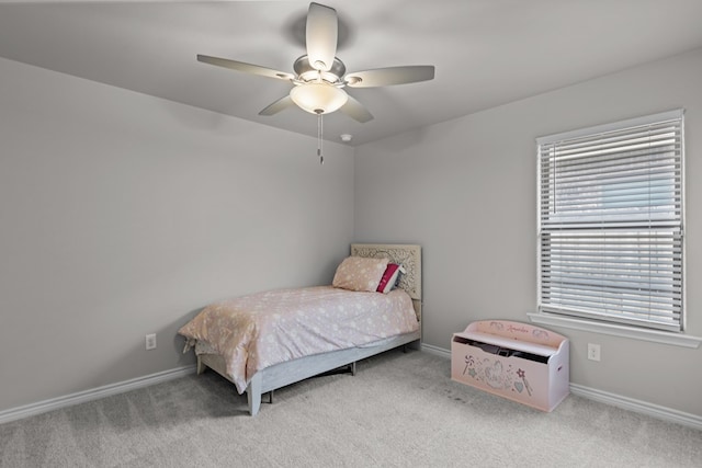 carpeted bedroom featuring multiple windows and ceiling fan