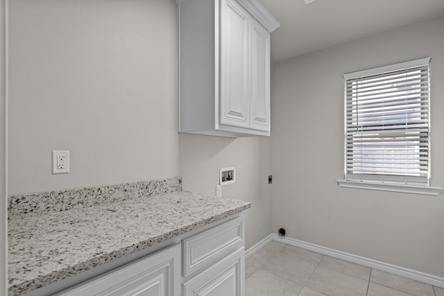 washroom featuring hookup for an electric dryer, cabinets, light tile patterned floors, and hookup for a washing machine