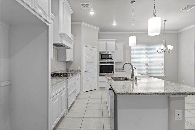 kitchen featuring sink, hanging light fixtures, a kitchen island with sink, white cabinets, and appliances with stainless steel finishes