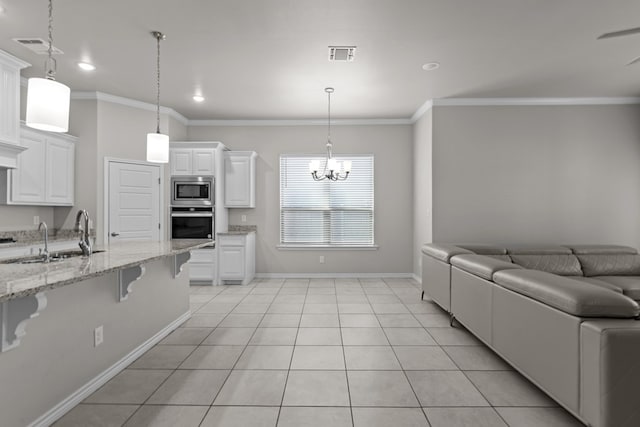 kitchen featuring sink, stainless steel appliances, crown molding, a breakfast bar, and white cabinets