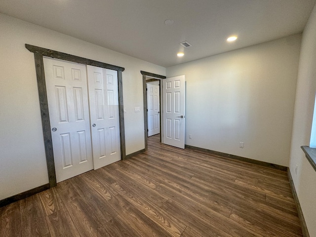 unfurnished bedroom featuring a closet and dark hardwood / wood-style floors