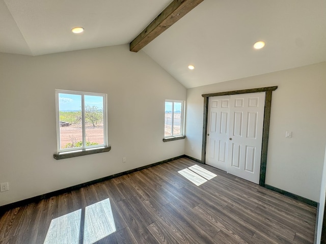 unfurnished bedroom featuring lofted ceiling with beams, a closet, and dark wood-type flooring