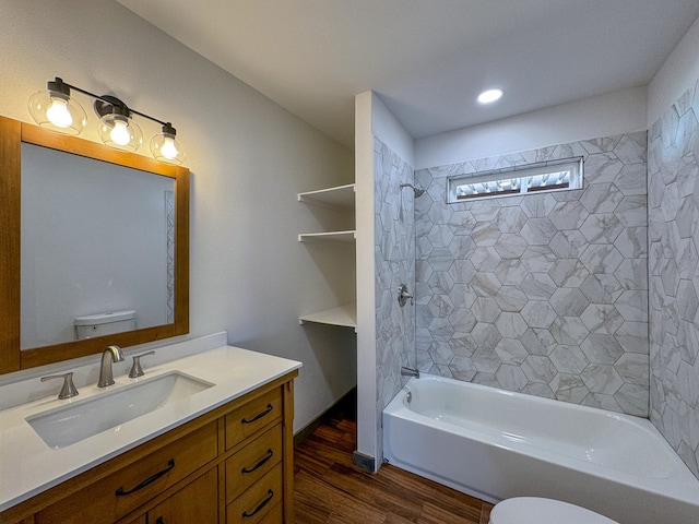 full bathroom featuring vanity, toilet, wood-type flooring, and tiled shower / bath combo