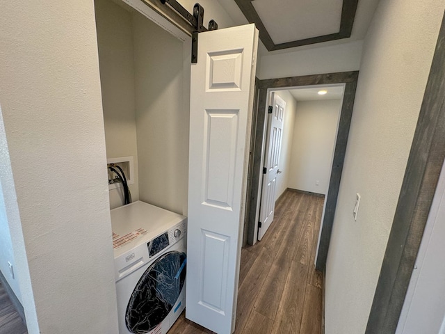 washroom featuring dark hardwood / wood-style floors, a barn door, and washer / clothes dryer