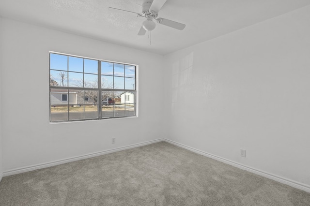 carpeted empty room featuring ceiling fan and a textured ceiling