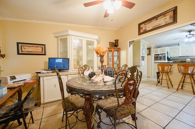 tiled dining area with lofted ceiling, a textured ceiling, and crown molding