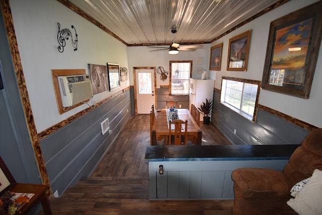 dining room featuring dark hardwood / wood-style floors, a wall unit AC, ceiling fan, and crown molding