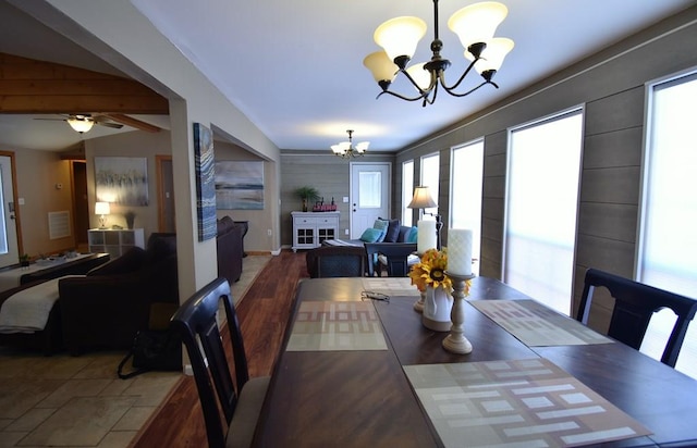 dining area with ceiling fan with notable chandelier and hardwood / wood-style flooring