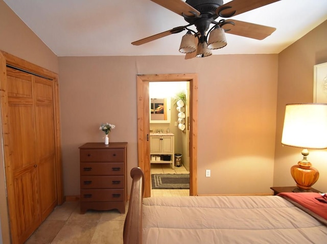 tiled bedroom with sink, vaulted ceiling, ensuite bath, ceiling fan, and a closet