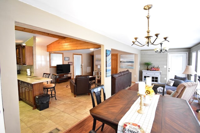 dining area with vaulted ceiling and an inviting chandelier