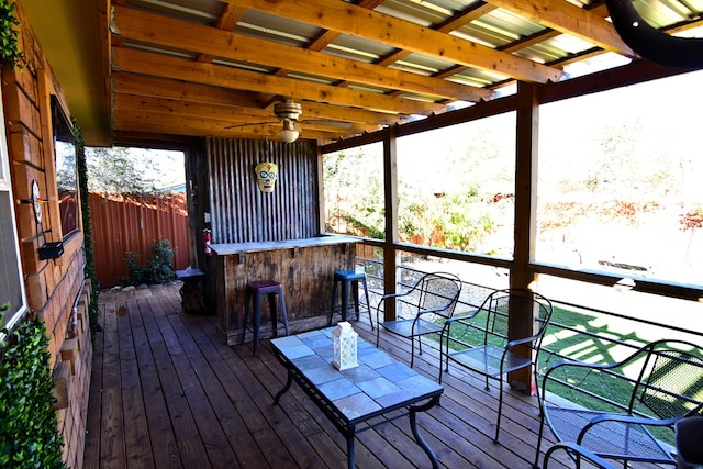 deck featuring ceiling fan and exterior bar