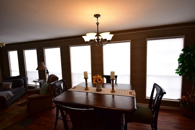 dining area featuring dark wood-type flooring, a wealth of natural light, and a chandelier