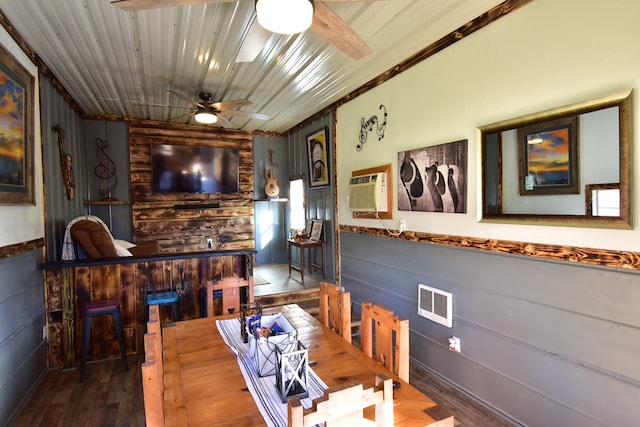 dining area with wood walls, hardwood / wood-style floors, ceiling fan, and a wall mounted air conditioner