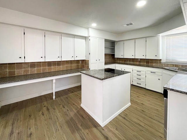 kitchen featuring tasteful backsplash, dark wood-style flooring, a kitchen island, and white cabinetry