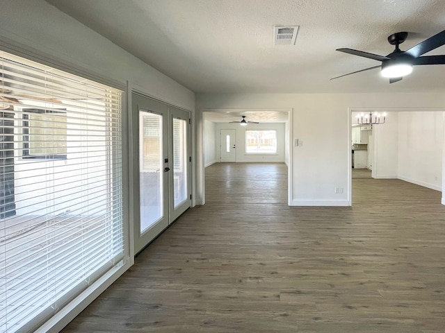 unfurnished room featuring a textured ceiling, french doors, dark wood-style flooring, and visible vents