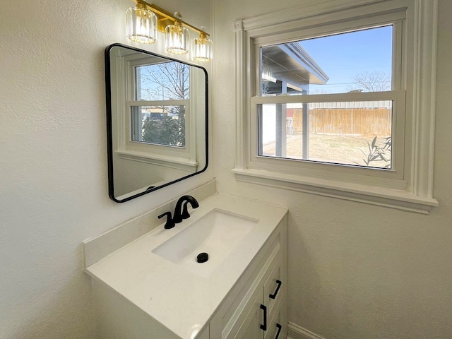 bathroom with a textured wall and vanity