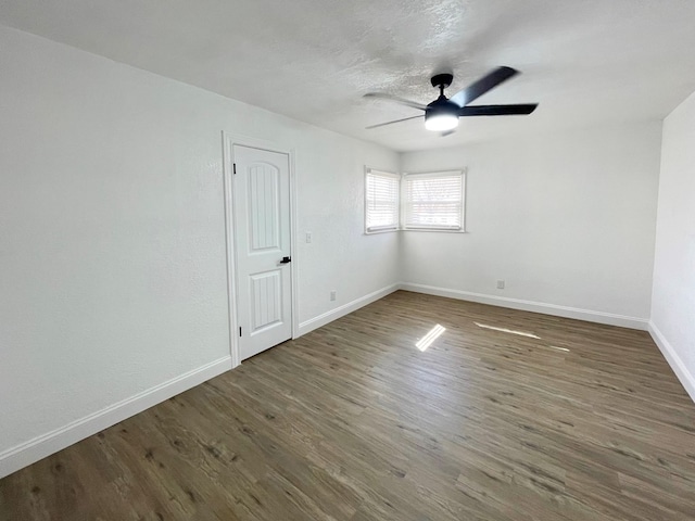 unfurnished room with ceiling fan, a textured ceiling, baseboards, and wood finished floors