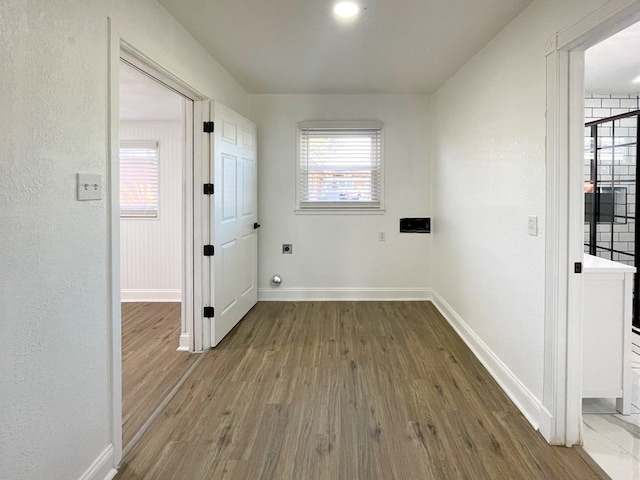 laundry area with baseboards, hookup for an electric dryer, and wood finished floors