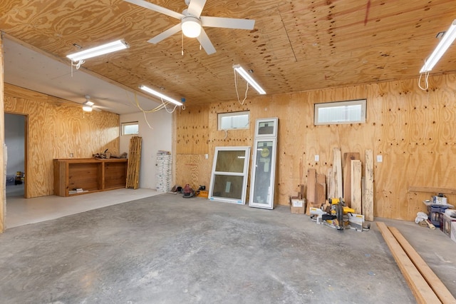 garage featuring a workshop area, wooden ceiling, and wooden walls