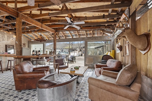 living room with beamed ceiling, a wealth of natural light, and ceiling fan