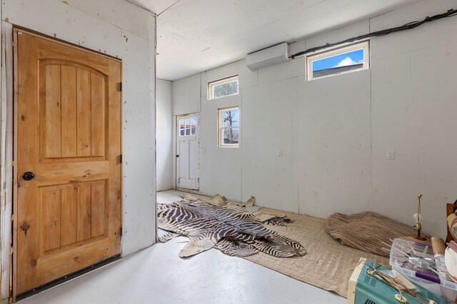 bedroom with an AC wall unit and multiple windows