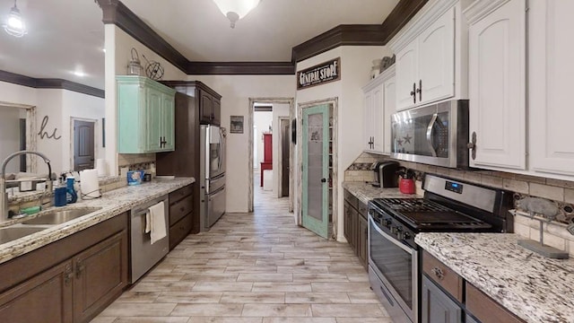 kitchen featuring white cabinets, dark brown cabinetry, sink, and appliances with stainless steel finishes