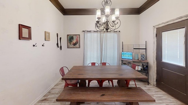 dining room with light wood-type flooring, crown molding, and an inviting chandelier