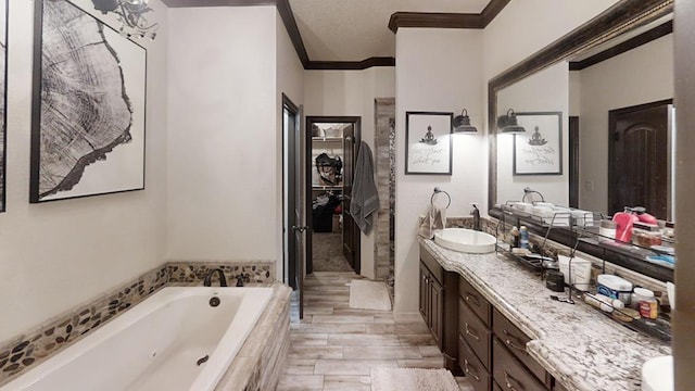 bathroom with ornamental molding, vanity, wood-type flooring, a relaxing tiled tub, and a notable chandelier