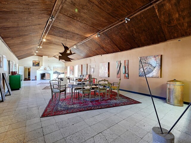 dining room with wooden ceiling, high vaulted ceiling, and track lighting