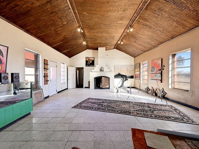 unfurnished living room with a wealth of natural light, rail lighting, and wooden ceiling