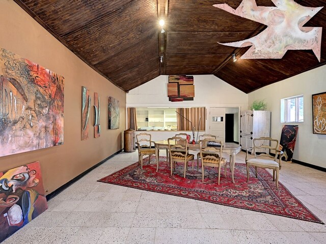 dining area featuring high vaulted ceiling and wooden ceiling