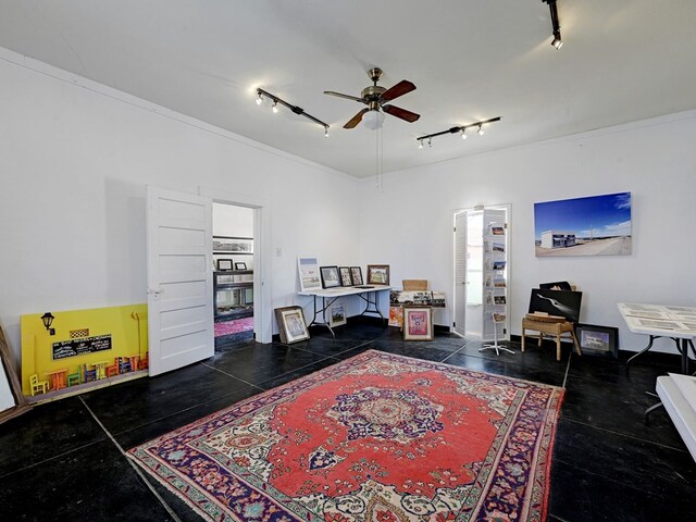 interior space featuring rail lighting, ceiling fan, and ornamental molding