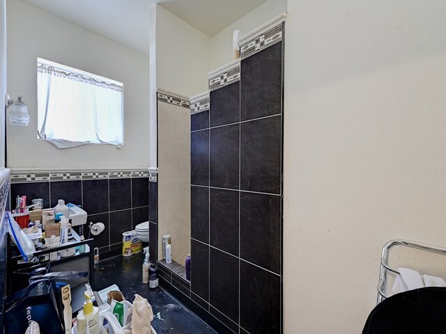 bathroom featuring tile walls and toilet