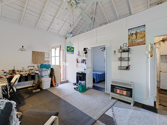 interior space featuring carpet flooring, beamed ceiling, high vaulted ceiling, and heating unit