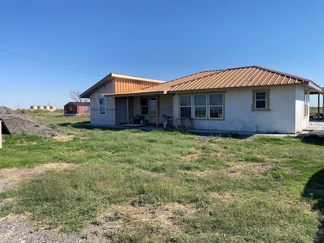 rear view of house featuring a yard