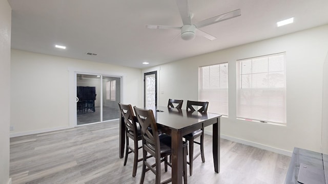 dining room featuring ceiling fan, a wealth of natural light, and light wood-type flooring