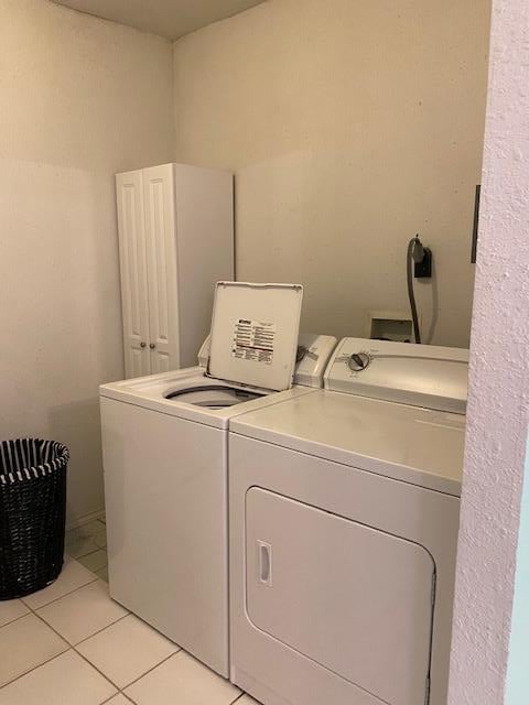 laundry room with light tile patterned floors and washer and clothes dryer