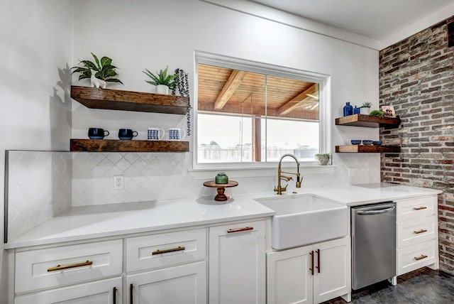 kitchen featuring white cabinetry, sink, decorative backsplash, and brick wall