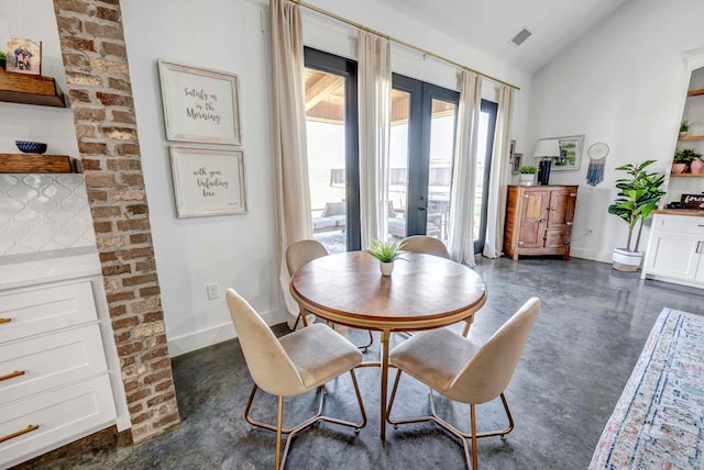 dining room featuring vaulted ceiling and french doors