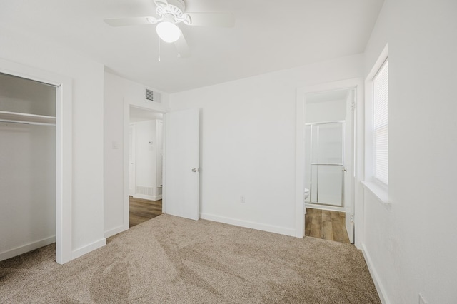 unfurnished bedroom featuring multiple windows, carpet, a closet, and visible vents